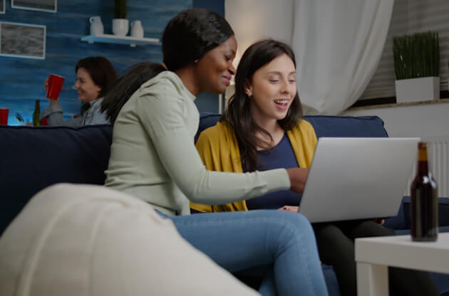 Relaible Internet for life in Nova Scotia - Two ladies sitting on sofa using a laptop connected to NetJOI Internet