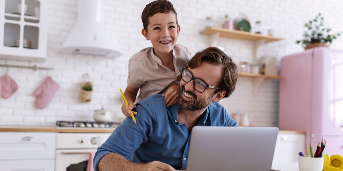 Best, Reliable and Most Affordable Internet Providers in Ontario for Under $50 per Month - Happy Father and Son in kitchen looking at laptop.