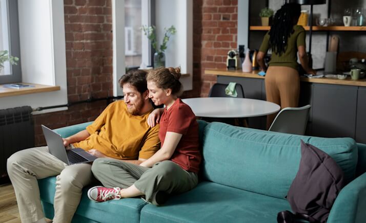 People in an apartment - couple in the sofa, lady in kitchen using NetJOI Internet