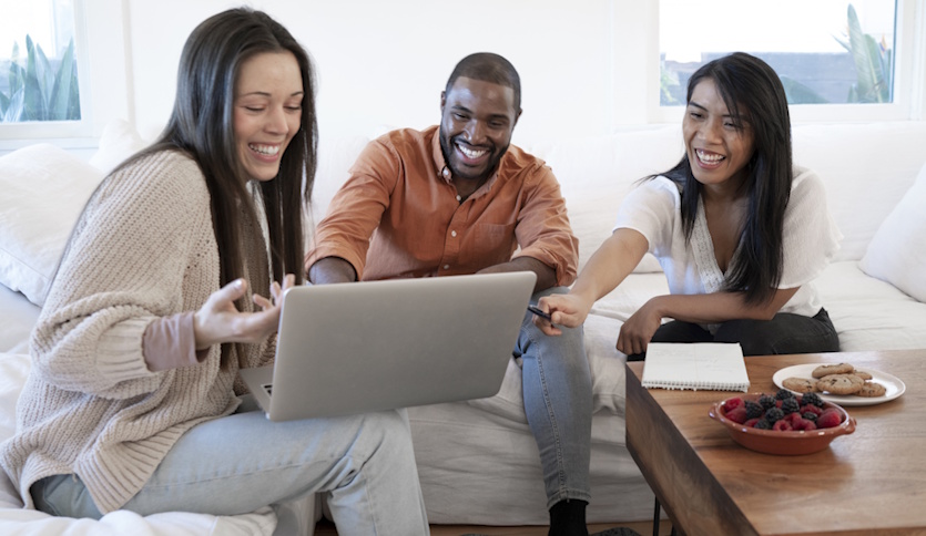 Best-Internet-Providers-in-Nova-Scotia-Under-65-3-people-sitting-on-sofa-smiling-looking-at-laptop