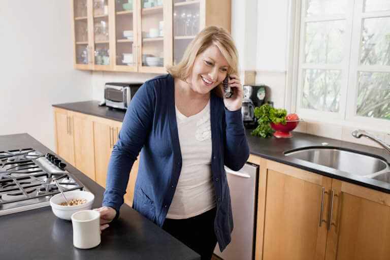 Woman using cordless home phone with NetJOI